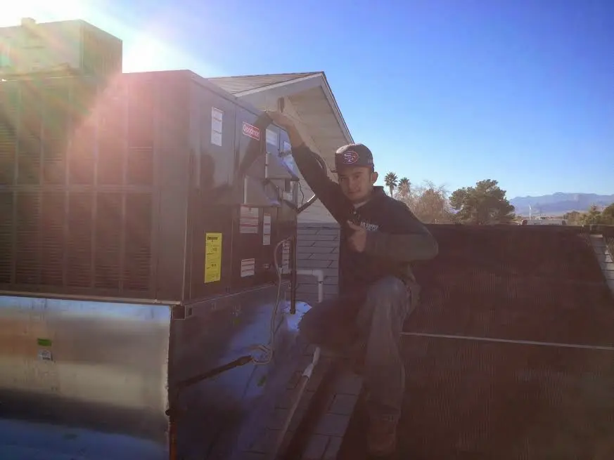 HVAC technician performing AC Tune-Up on a rooftop unit in West Carson